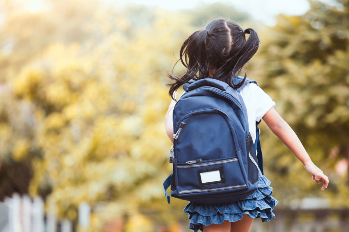 child running to school with backpack on