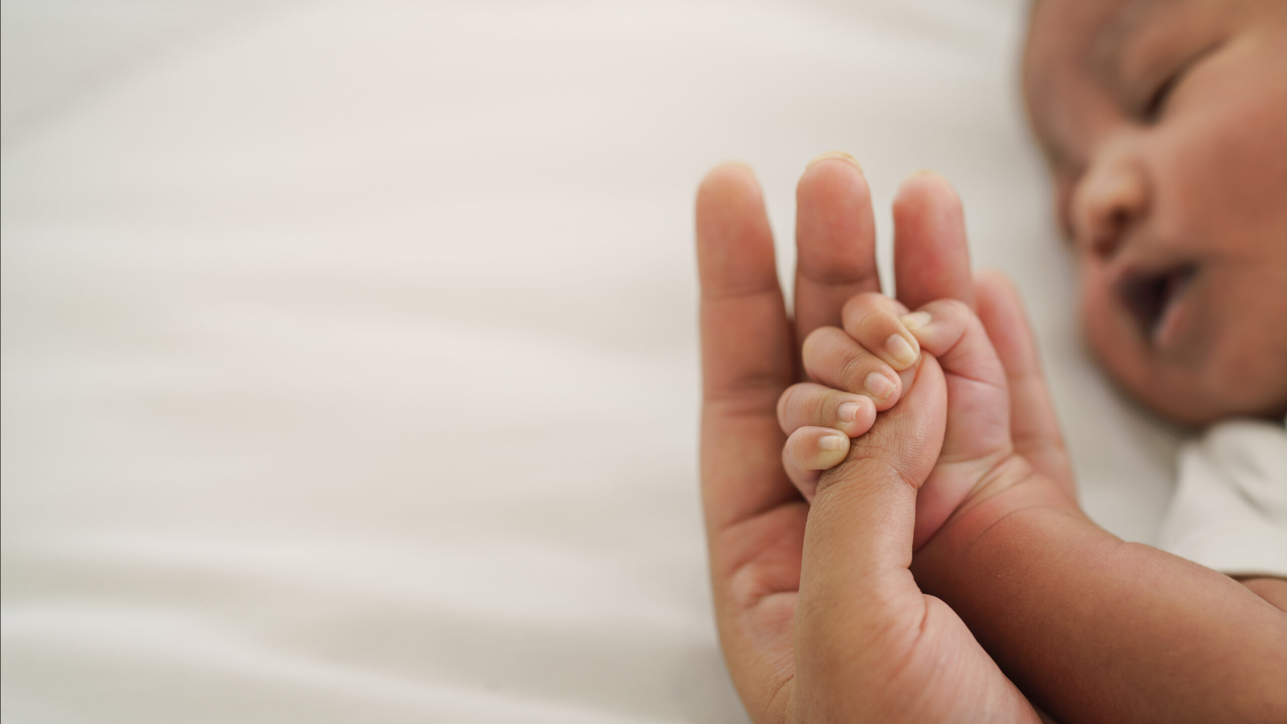 Baby grabbing his moms hand