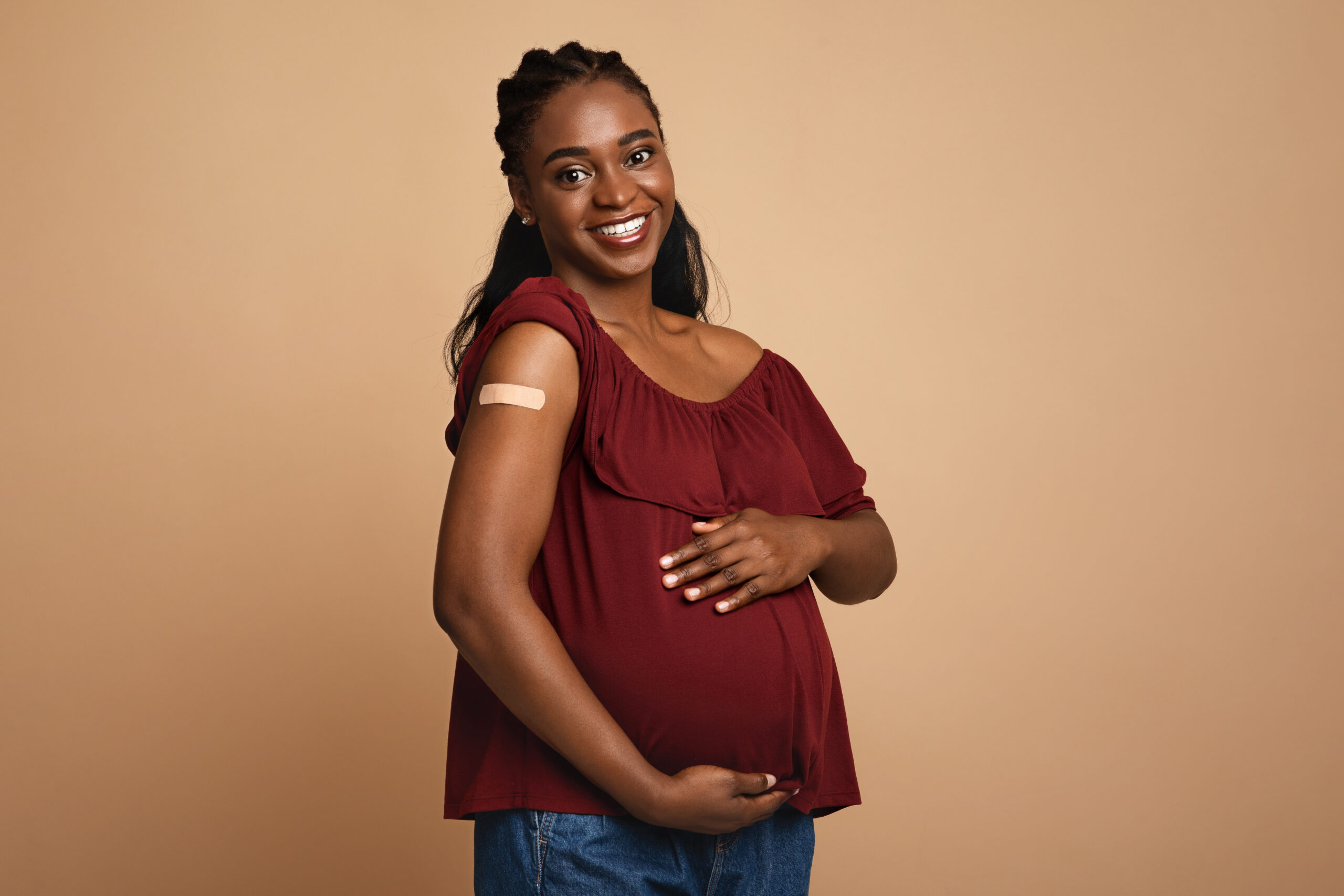 Pregnant woman with a bandaid on her arm