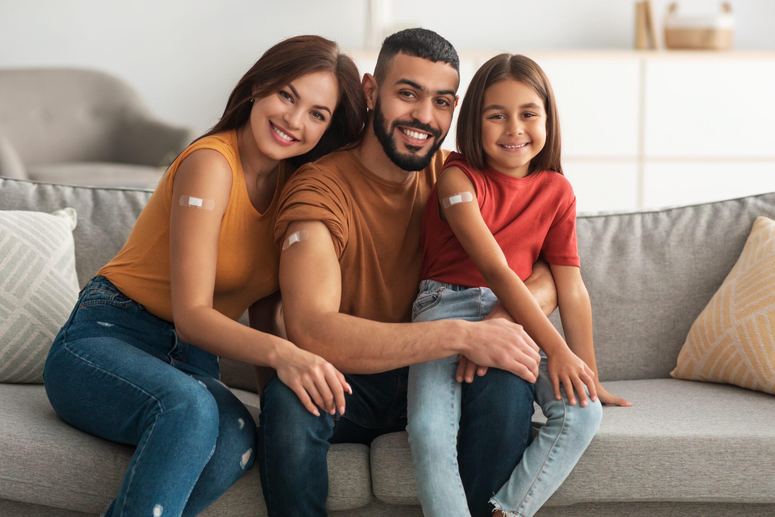 Mom, dad, and daughter with bandaids on their arms