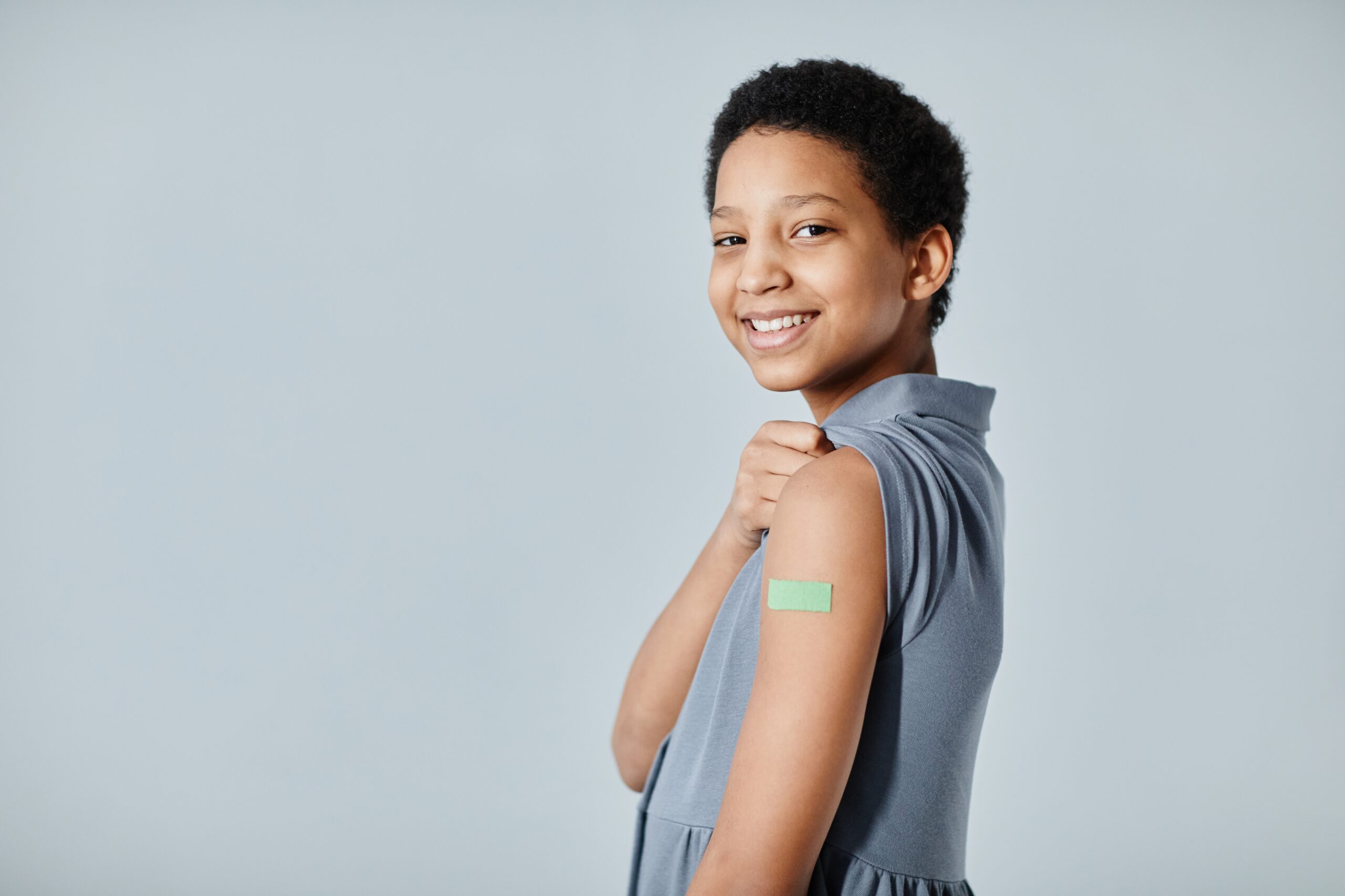 Boy smiling with a bandaid on his arm