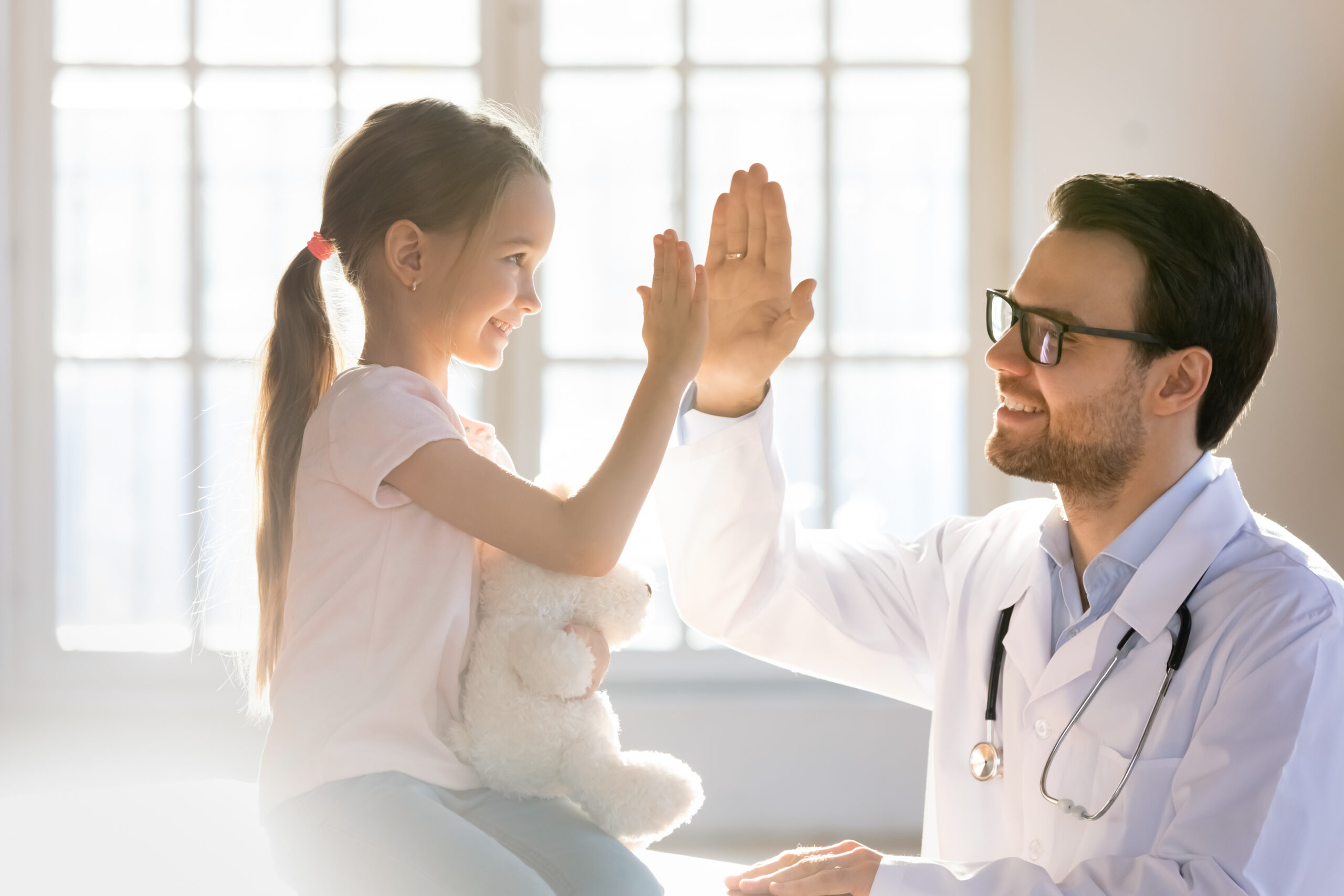 Young girl giving her doctor a high five