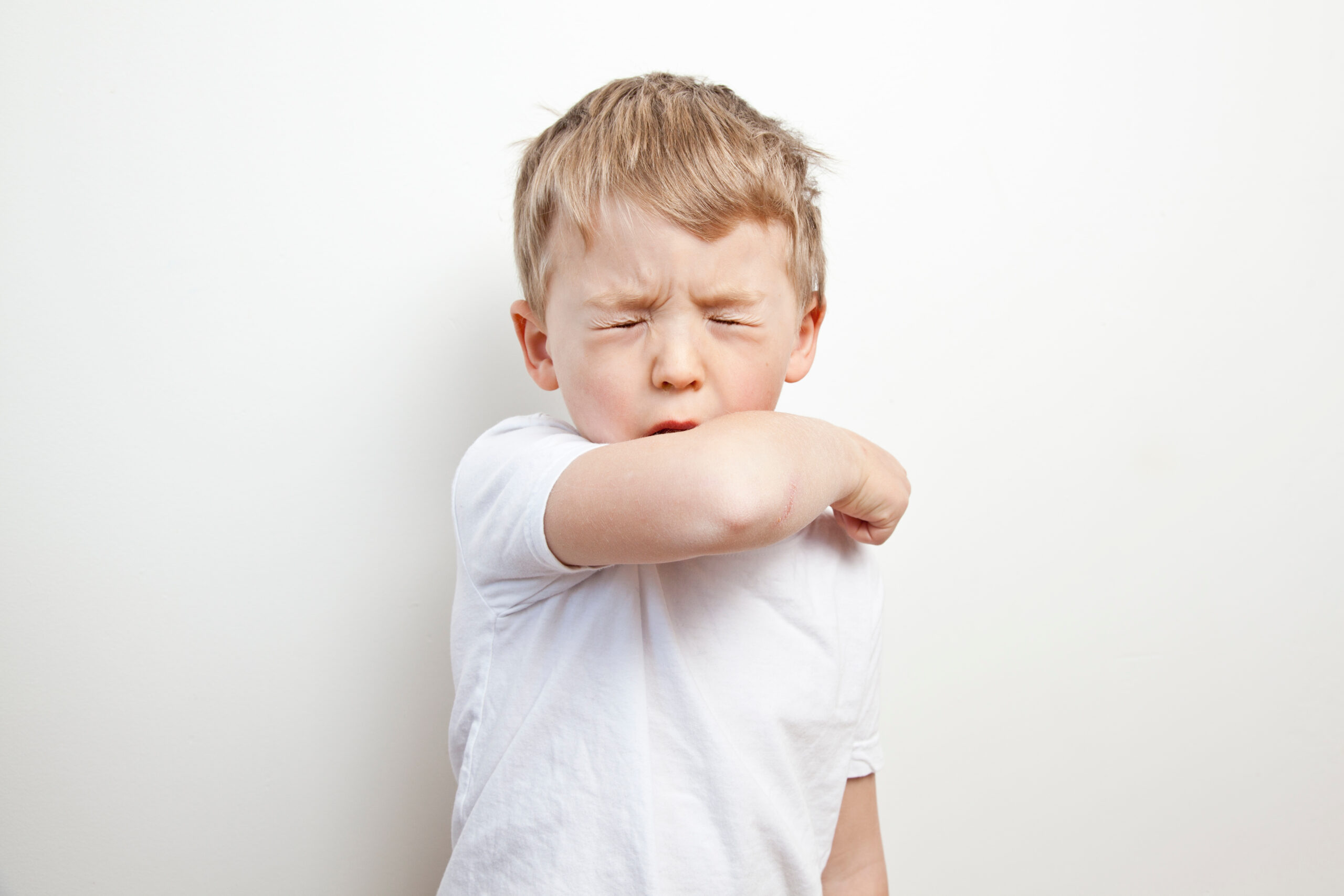 Child coughing into his elbow