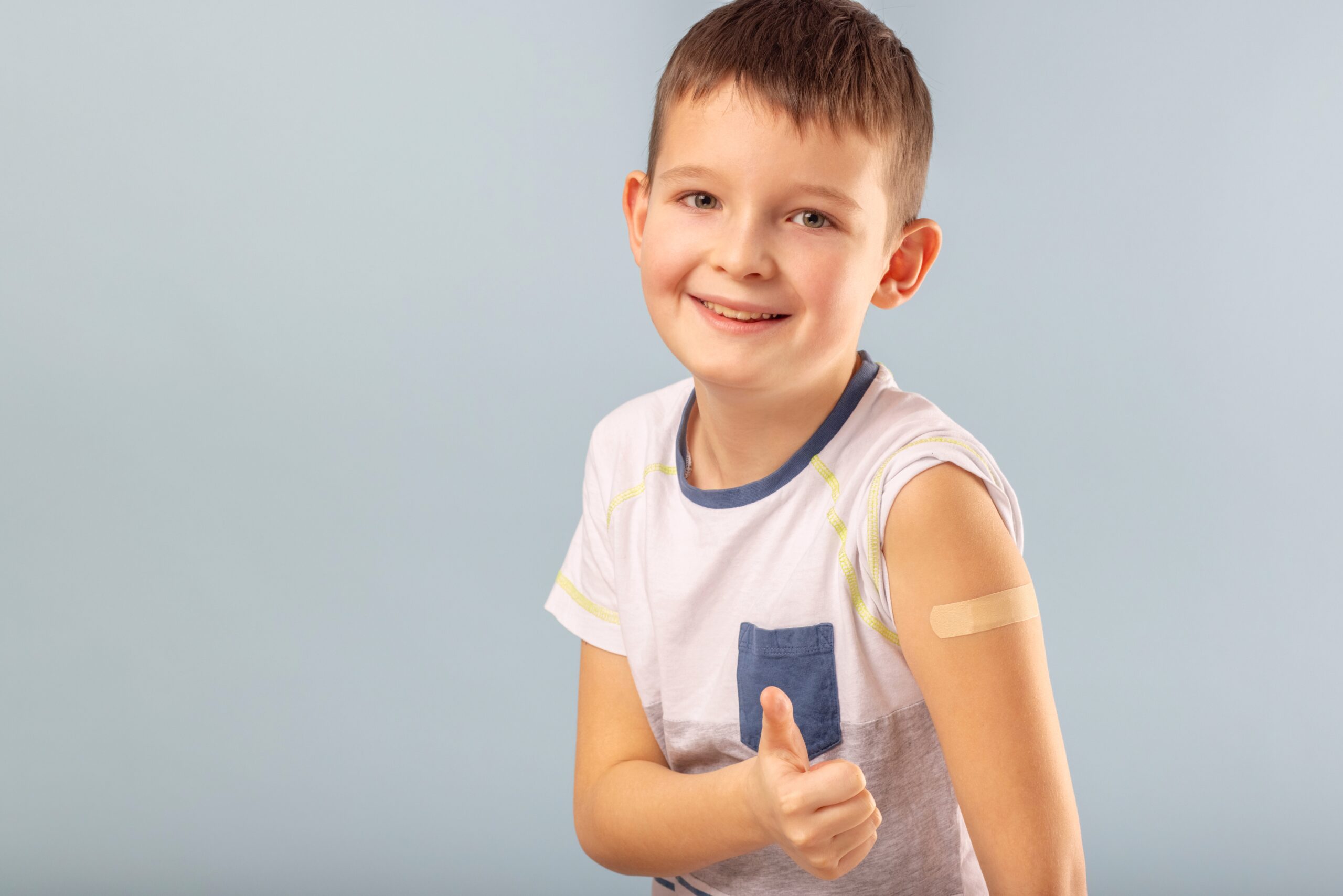Child giving thumbs up after vaccination