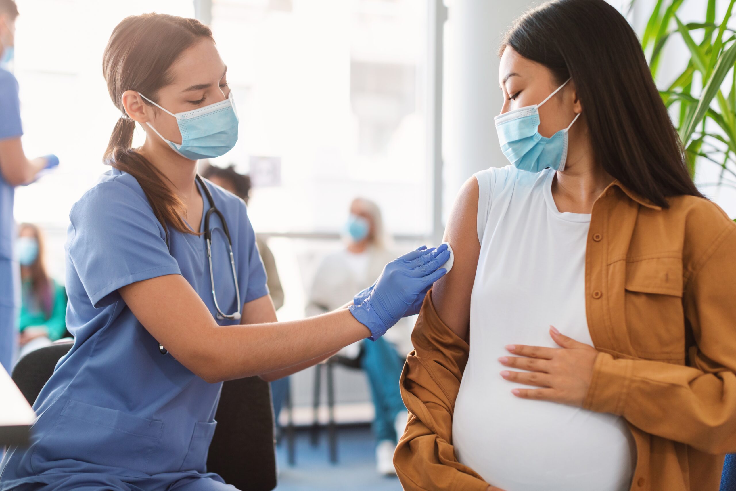 Pregnant mother and doctor preparing to receive a vaccination