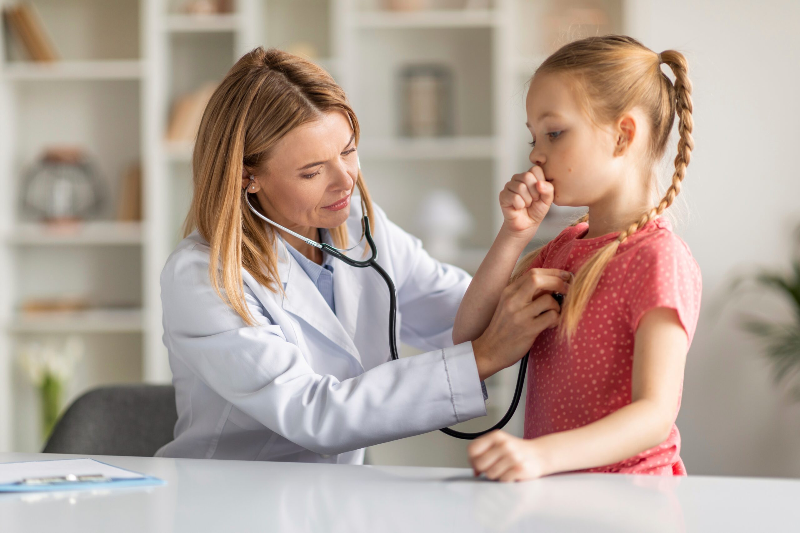 Doctor listening to child through stethoscope