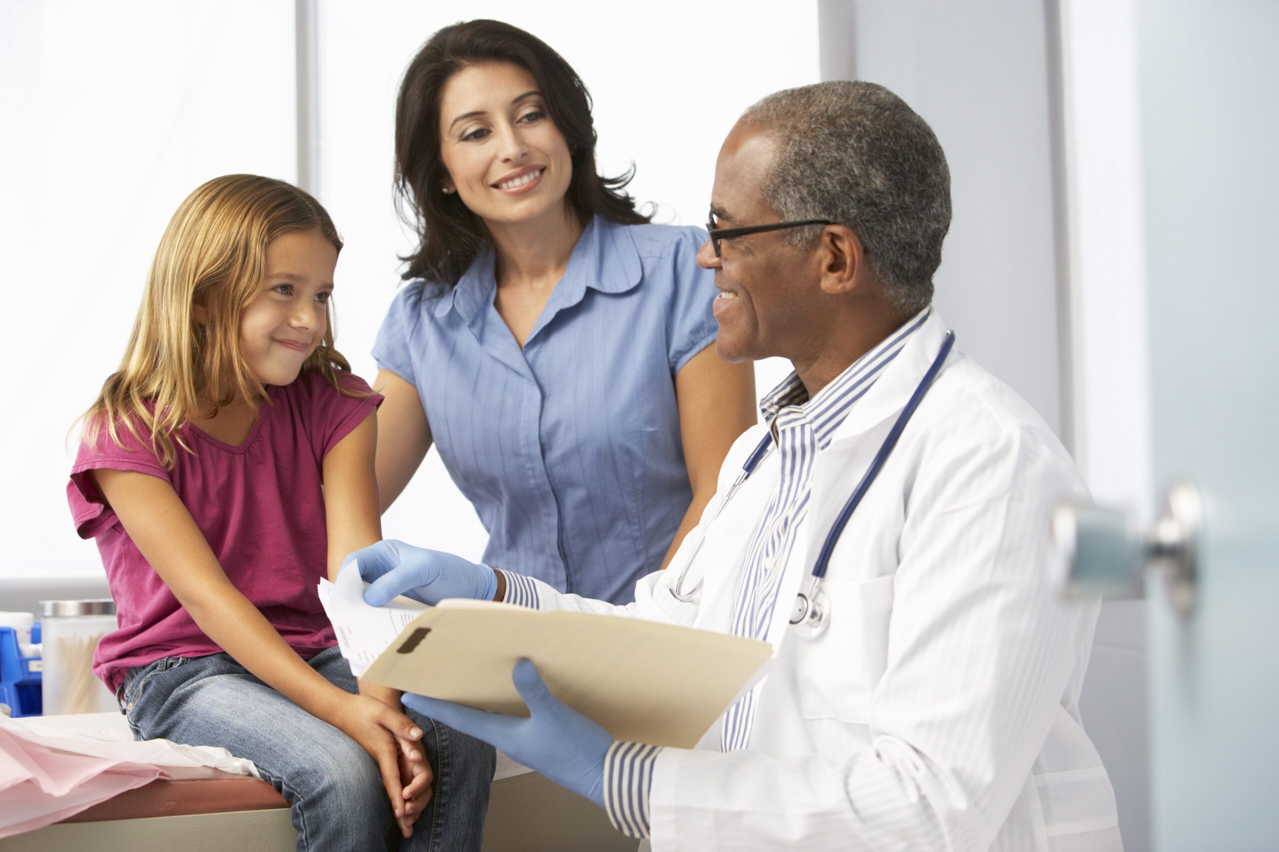 Doctor consulting mother and daughter at doctor's office