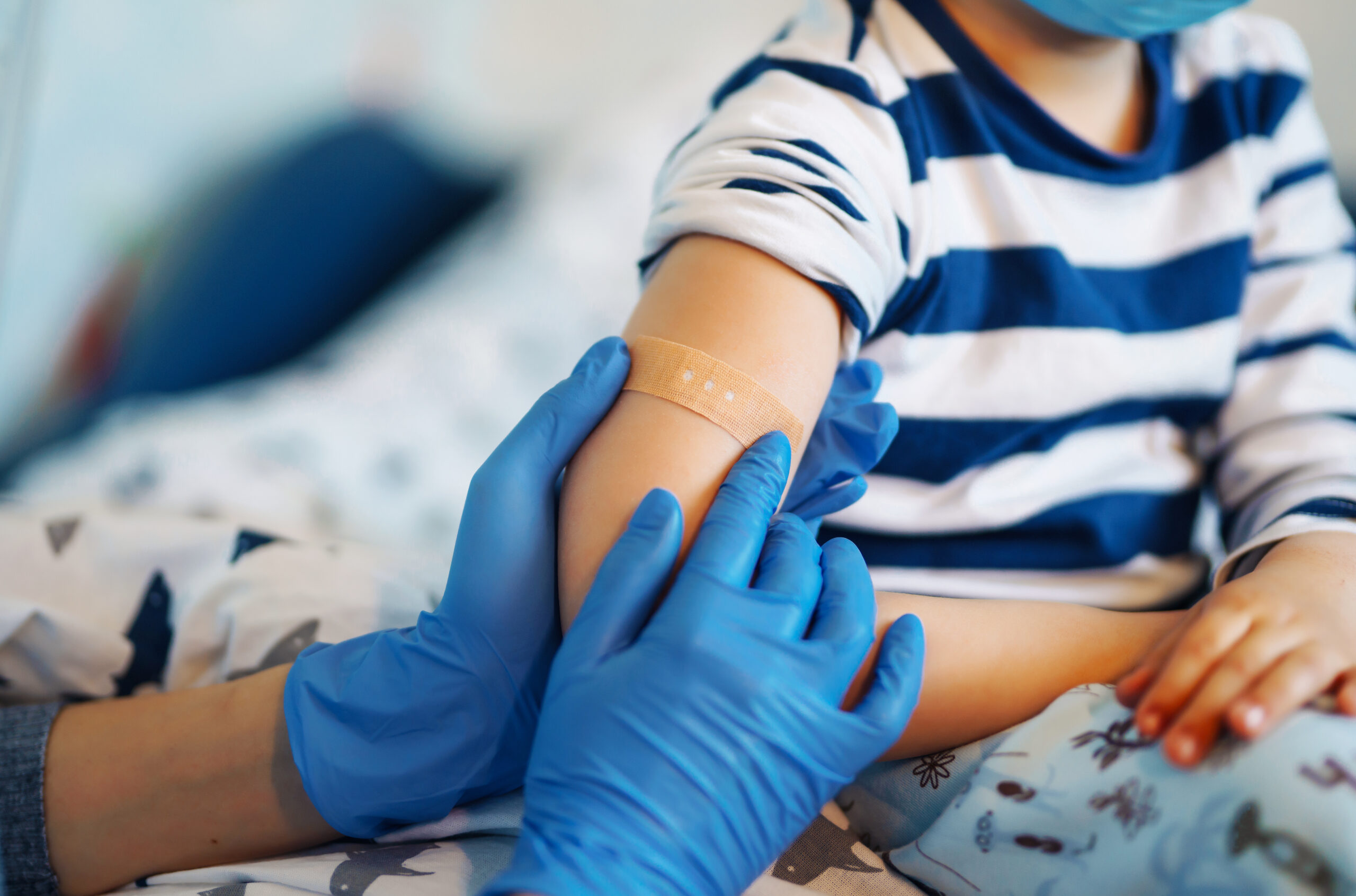 Doctor applying bandaid to child after vaccination
