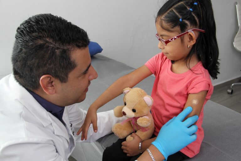 Male doctor talking to child after a vaccine